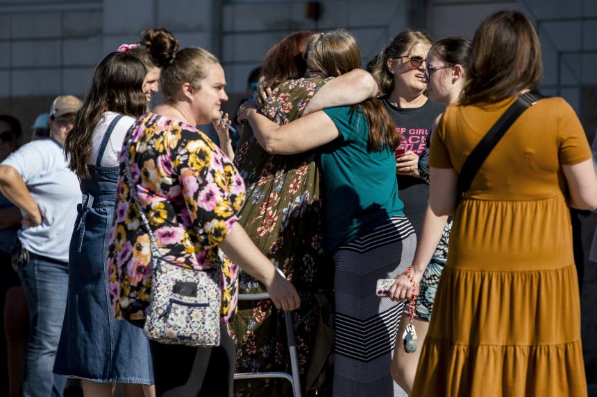 Church members and residents reunite Sunday at Trillium Theater across the street from the site of a shooting and fire at the Church of Jesus Christ of Latter-day Saints in Grand Blanc Township.