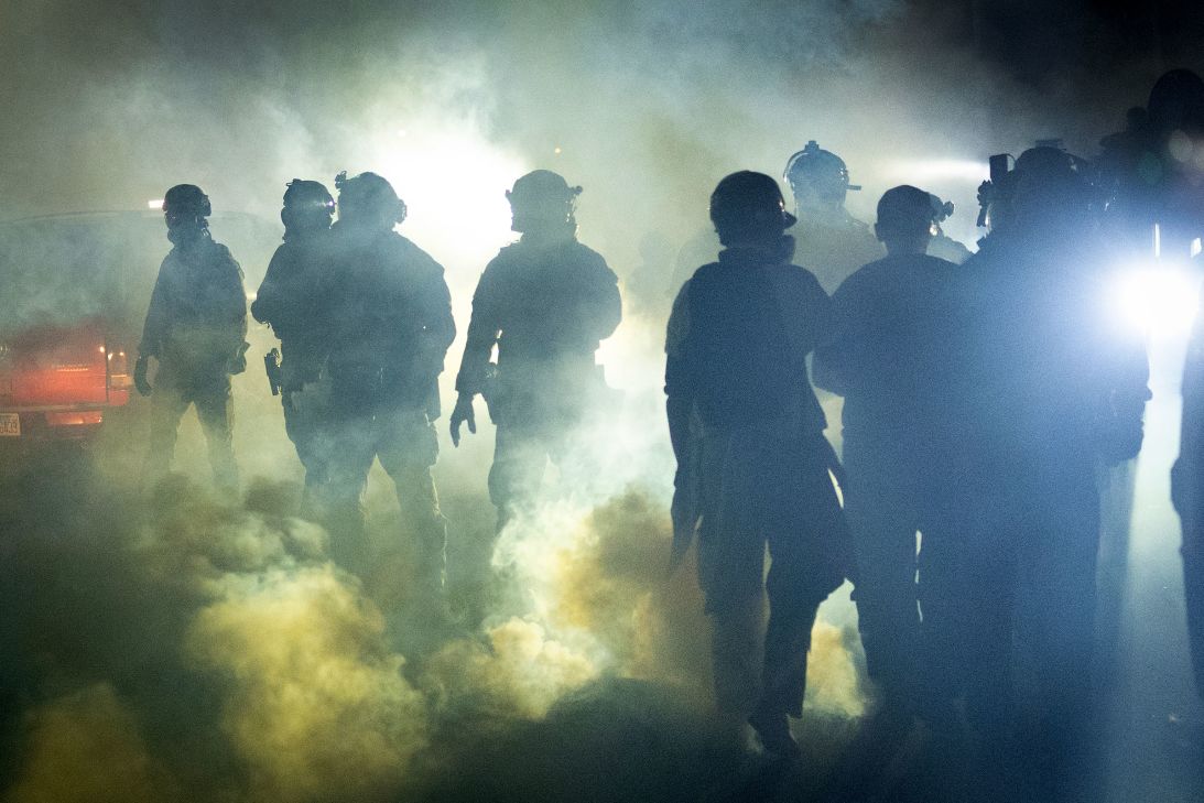 Federal law enforcement agents deploy tear gas against demonstrators protesting outside of an immigrant processing center in Broadview, Illinois, on September 27.