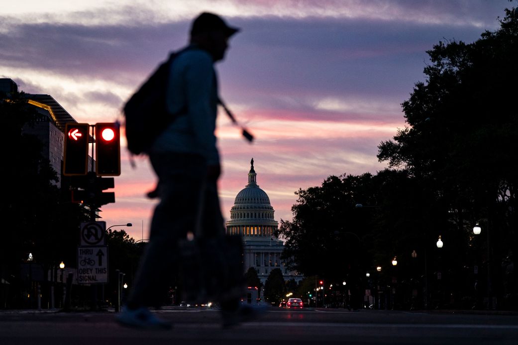 People cross Pennsylvania Avenue near the US Capitol at dawn on October 1, 2025, the first day of the government shutdown.