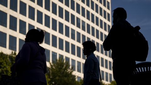 Commuters cross the street near the Federal Aviation Administration (FAA) headquarters on October 1, 2025 in Washington, DC. Congress could not agree on a budget to fund the federal government so it has shut down.