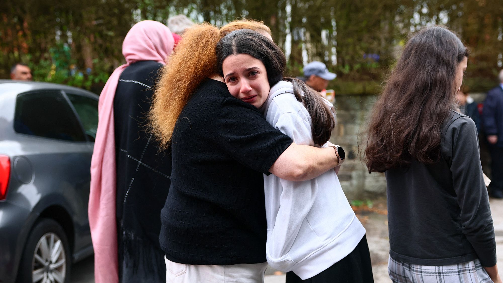 Members of the community comfort each other near Heaton Park Hebrew Congregation Synagogue in Crumpsall, north Manchester, on October 2, 2025, following a "major incident" at the synagogue. Four people were injured and a suspected knifeman shot by police Thursday after a car ramming and stabbing incident outside a synagogue in Manchester, officials said. Greater Manchester Police declared a "major incident" shortly after 9:30am (0830 GMT) after officers were called to the Heaton Park Hebrew Congregation Synagogue in the Crumpsall neighbourhood of the northwestern city. (Photo by Paul Currie / AFP) (Photo by PAUL CURRIE/AFP via Getty Images)