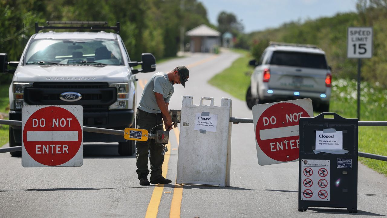 EVERGLADES NATIONAL PARK, FLORIDA - OCTOBER 01: A worker locks the gate to the entrance of Everglades National Park Shark Valley due to the government shutdown on October 01, 2025, in Everglades National Park, Florida. The park will remain open to visitors, but with minimal staffing. The U.S. government shut down at midnight, with President Donald Trump and Democrats blaming each other for failing to reach an agreement. (Photo by Joe Raedle/Getty Images)