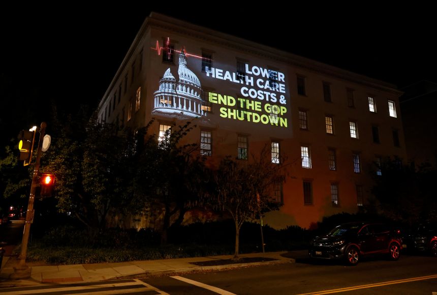 Las imágenes proyectadas al lado de un edificio de Washington, D.C., el miércoles por la noche, culpan a los republicanos por el cierre y buscan fondos de atención médica.