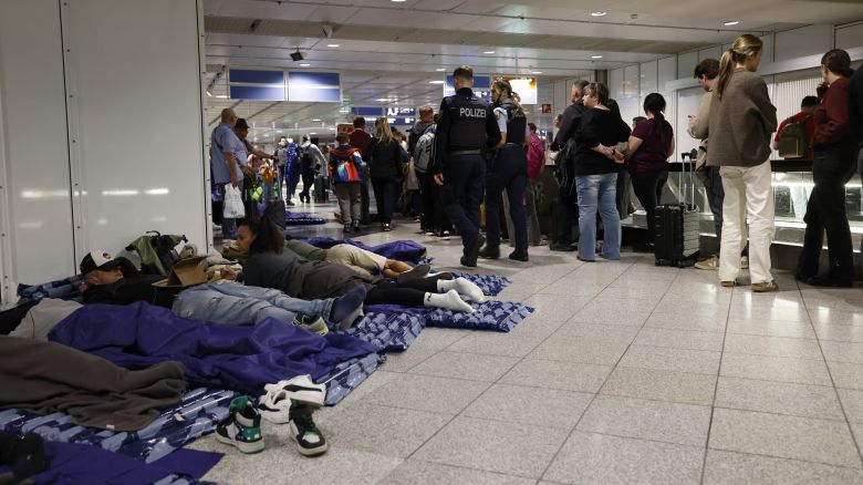 Passengers slept on inflatable mattresses on the ground while others queued up next to them at Munich International Airport in Munich, southern Germany, on October 4, 2025, after reports of drone sightings forced the airport to close for a second time in two days.