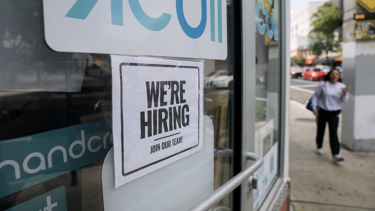 A sign is taped to the window of a business on October 3 in Miami. Due to the government shutdown, the Bureau of Labor Statistics is not releasing any official federal employment data.