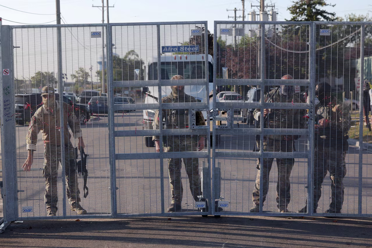 Federal agents stand next to a gate outside the Immigration and Customs Enforcement holding facility in Broadview, Illinois, on September 30.