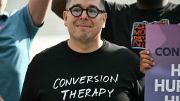 A man wears a shirt reading "conversion therapy dropout" gathers with demonstrators outside the US Supreme Court in Washington, DC, on October 7, 2025, as the Court hears oral arguements in Chiles v. Salazar, a landmark case on conversion therapy.