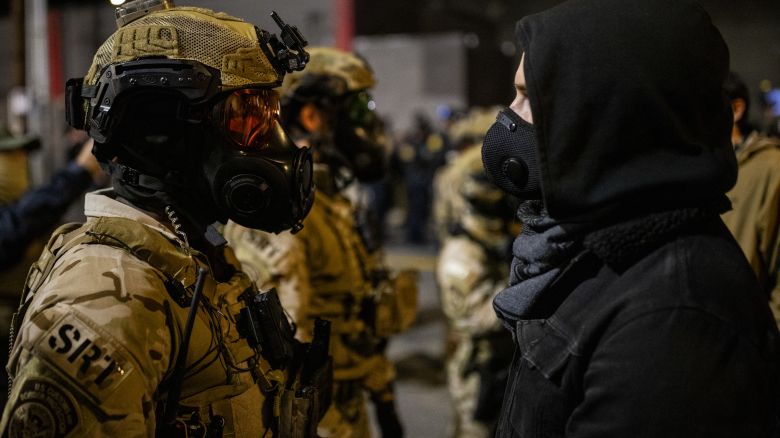 An officer with the Department of Homeland Security Special Response Team (SRT) stands against a protester outside a United States Immigration and Customs Enforcement (ICE) facility as protests against the Trump administration continue in Portland, Ore., Monday, Oct. 6, 2025.