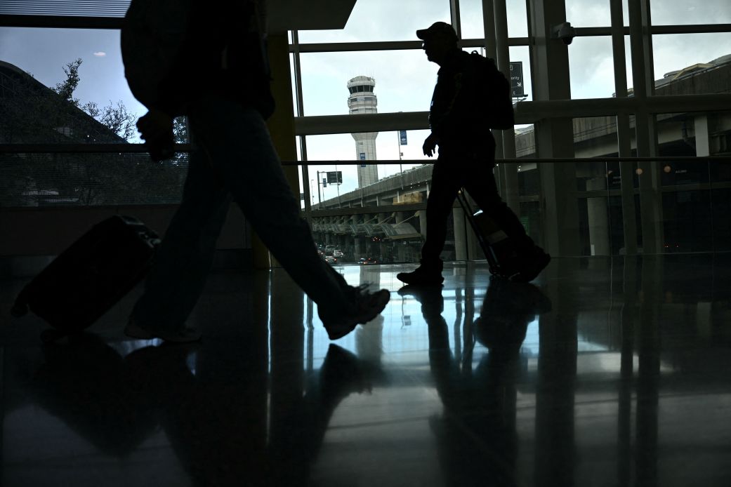 People walk through Reagan National Airport in Arlington, Virginia, on October 8, 2025.