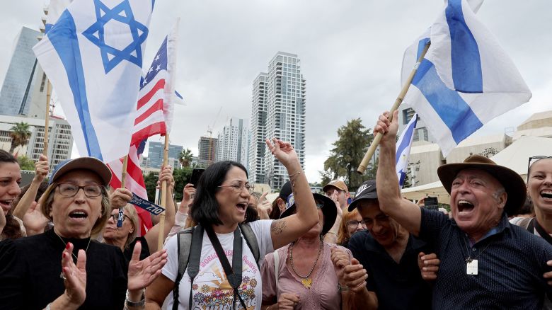 TOPSHOT - People wave US and Israeli flags at Hostage Square in Tel Aviv on October 9, 2025, following the announcement of a new Gaza ceasefire deal. Israel and Hamas on October 9 agreed a Gaza ceasefire deal to free the remaining living hostages, in a major step towards ending a war that has killed tens of thousands of people and unleashed a humanitarian catastrophe. (Photo by Jack GUEZ / AFP) (Photo by JACK GUEZ/AFP via Getty Images)          