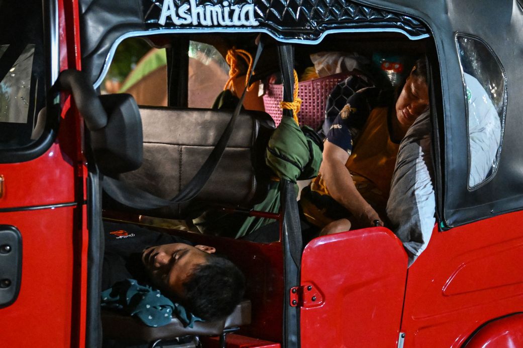 People sleep in a tricycle in Mati City after two powerful quakes struck off the southern Philippines, on Friday.