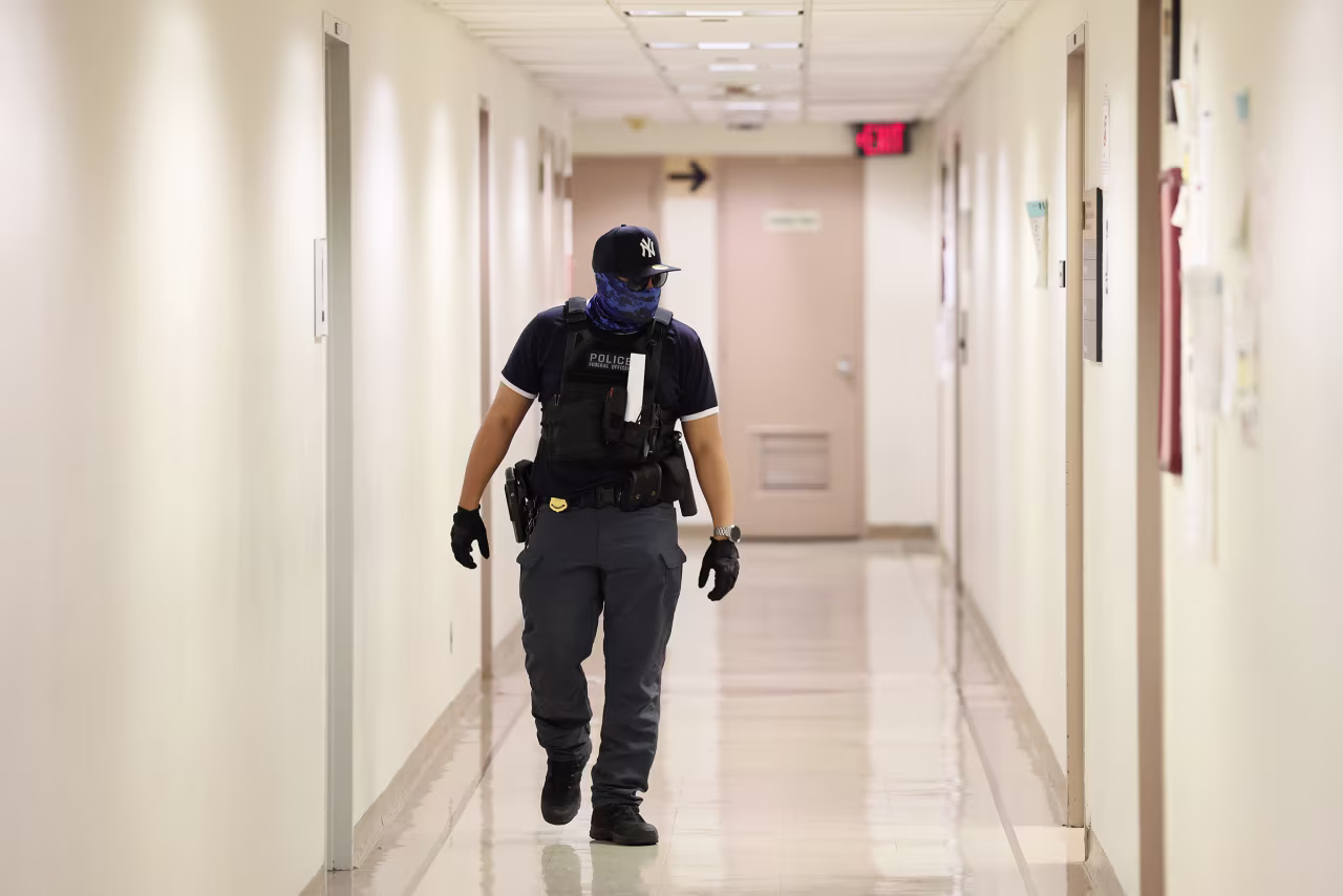 A federal agent patrols the halls of an immigration court in New York on October 9. Law enforcement personnel with the Department of Homeland Security, including ICE and Border Patrol agents, continue to be paid during a government shutdown.