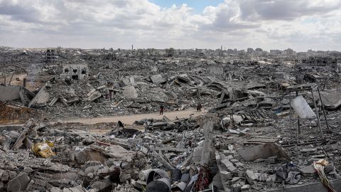 Palestinians walk through the ruins of destroyed buildings in the Al-Nafaq neighborhood of Gaza City on Sunday, after a cease-fire took effect and Israeli forces withdrew from parts of Gaza.