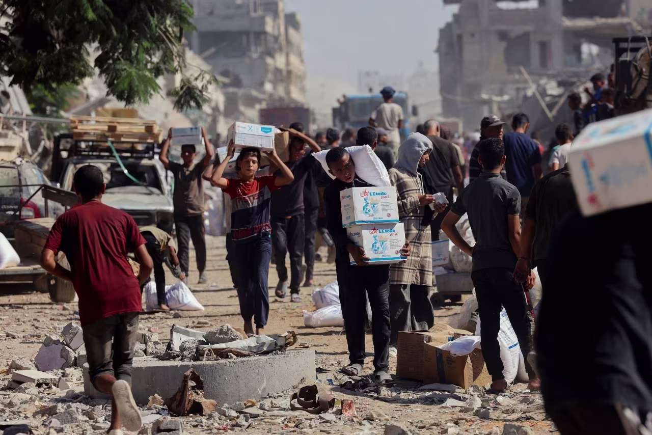 La gente camina por una calle muy dañada en Khan Younis, Gaza, este domingo.