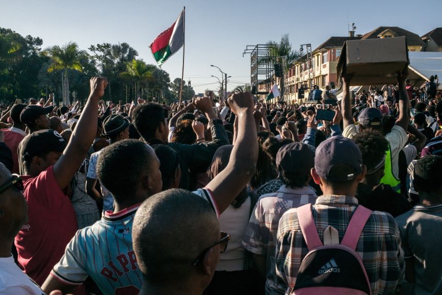 People cheer and hold banners as they gather for a rally outside City Hall in Antananarivo, Madagascar, on Monday.