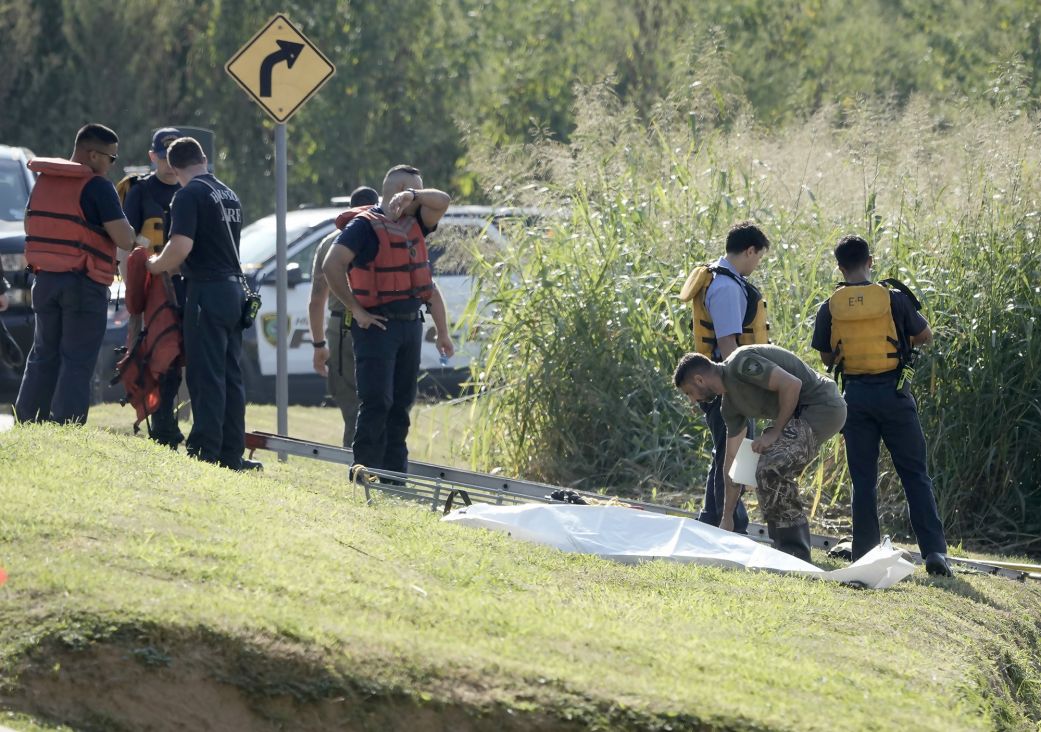 Houston fire and police personnel work to recover a body October 8 from White Oak Bayou near the Heights in Houston.