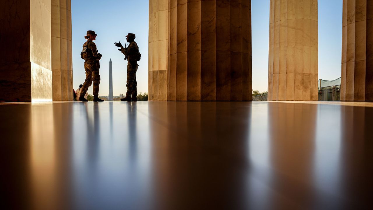 National Guard soldiers stand at the Lincoln Memorial on the National Mall in the early morning.