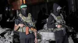 Palestinian militants wearing the uniform of the al-Qassam Brigades, the military wing of Hamas, monitor vehicles of the International Committee of the Red Cross as they collect the remains of Israeli hostages handed over by Hamas in Gaza City, Gaza, on Wednesday, October 15, 2025.