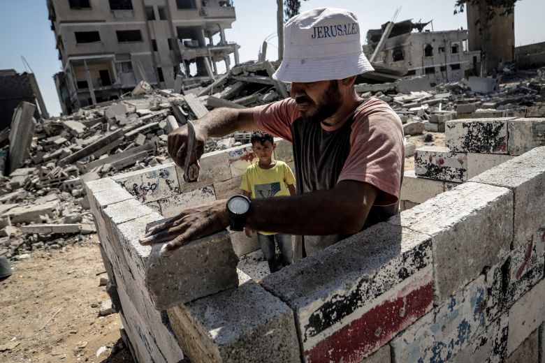 Palestinians in Gaza City begin rebuilding their demolished home using stones and materials salvaged from the rubble Thursday.
