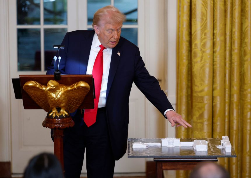 President Donald Trump points to a model of the White House and proposed ballroom as he delivers remarks during a ballroom fundraising dinner in the East Room of the White House on October 15.