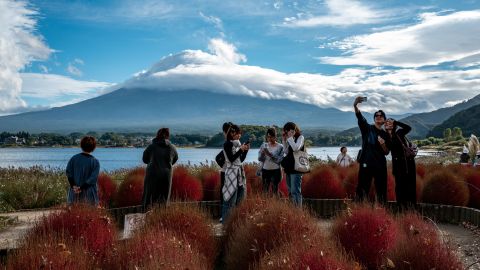 Tourists take pictures near Japan's Mount Fuji last month.