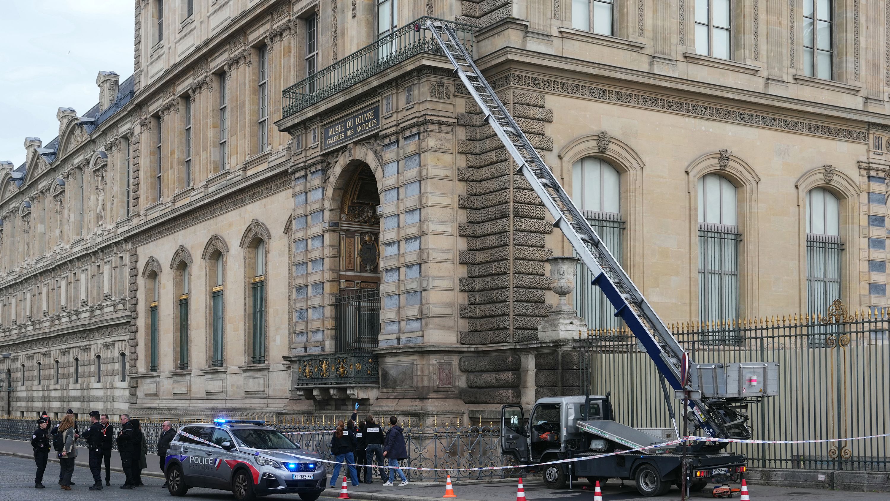 French police officers stand next to a furniture elevator used by robbers to enter the Louvre Museum, on Quai Francois Mitterrand, in Paris on October 19, 2025. Robbers broke in to the Louvre and fled with jewellery on October 19, 2025 morning, a source close to the case said, adding that its value was still being evaluated. A police source said an unknown number of thieves arrived on a scooter armed with small chainsaws and used a goods lift to reach the room they were targeting.
