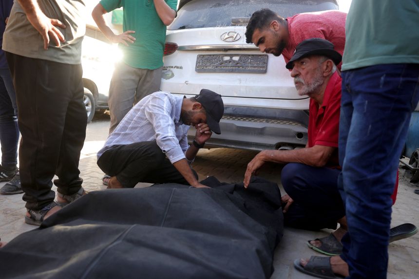 Friends and relatives mourn over the shrouded body of a man killed in an Israeli strike in central Gaza Strip on Sunday.