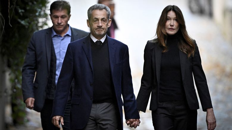 France's former president Nicolas Sarkozy, center left, with his wife Carla Bruni-Sarkozy, leaves his residence to present himself to La Sante Prison for incarceration on a five-year prison sentence in Paris, France, on October 21.