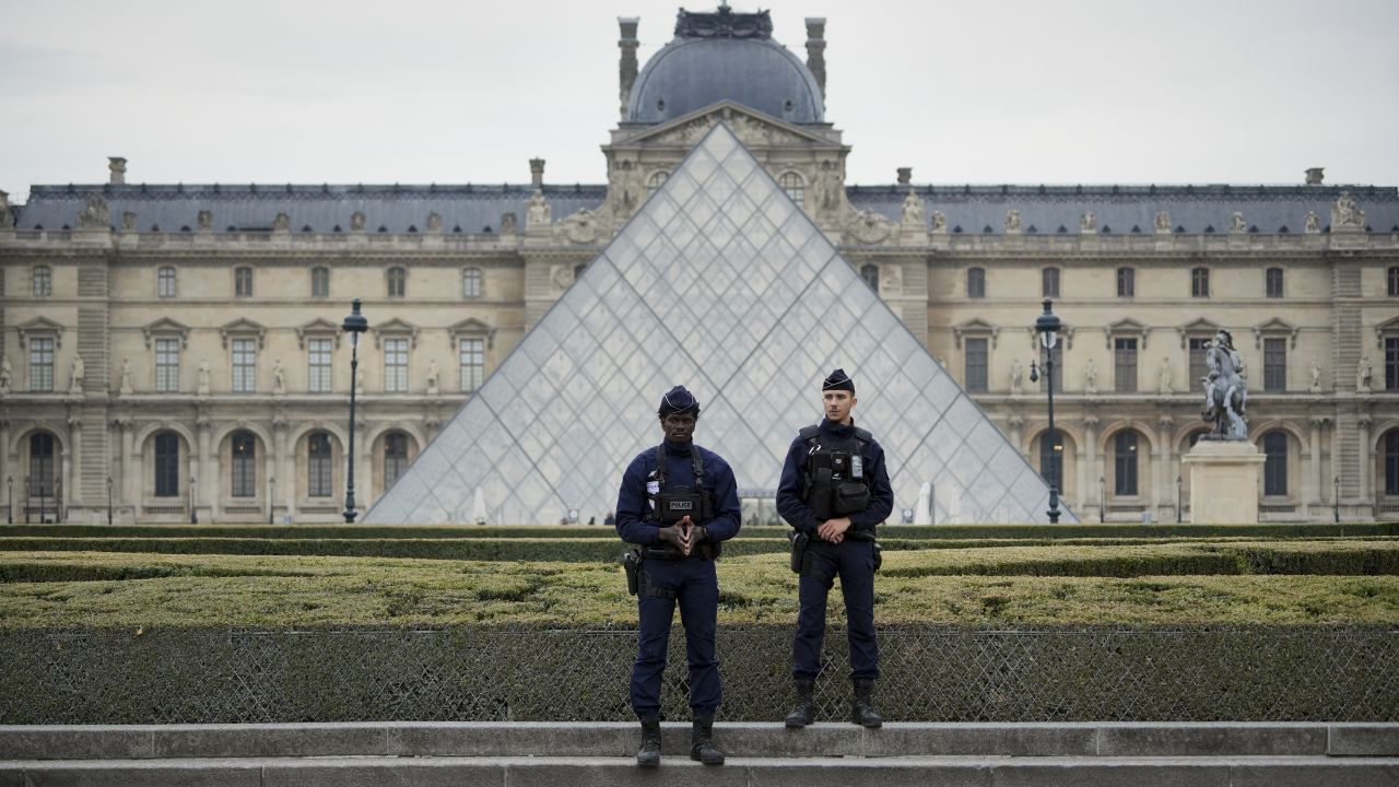 Police stand guard outside the Louvre museum at Louvre on October 19, 2025 in Paris, France.