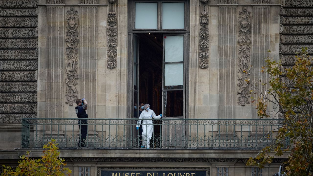 A French Forensics Officer examines the cut window and balcony of a gallery at the Louvre Museum which was the scene of a robbery at the world famous museum earlier in the day in Paris on October 19, 2025.