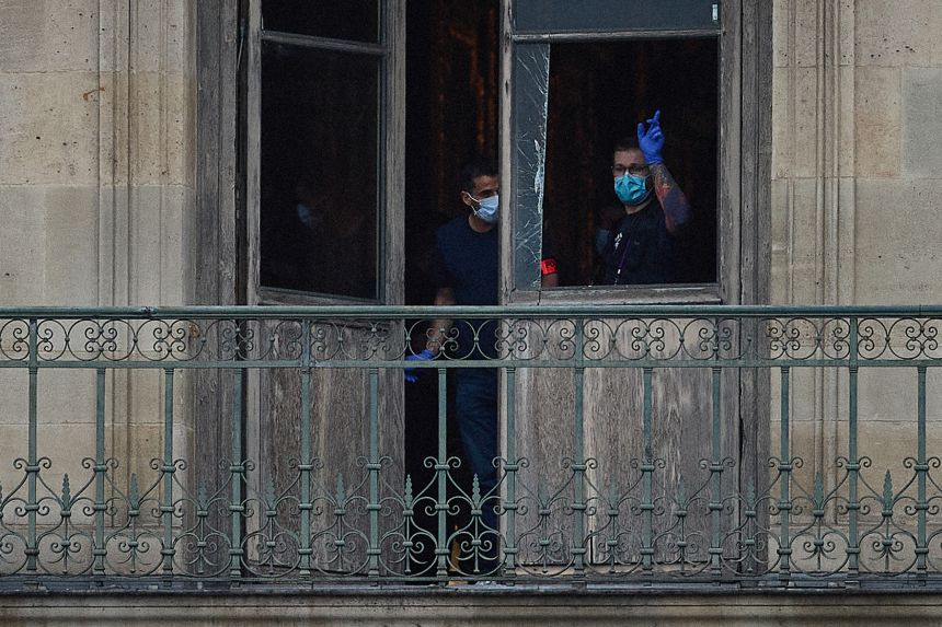A French crime scene officer gestures through a window where thieves are believed to have gained access to jewels at the Louvre Museum on October 19, 2025.