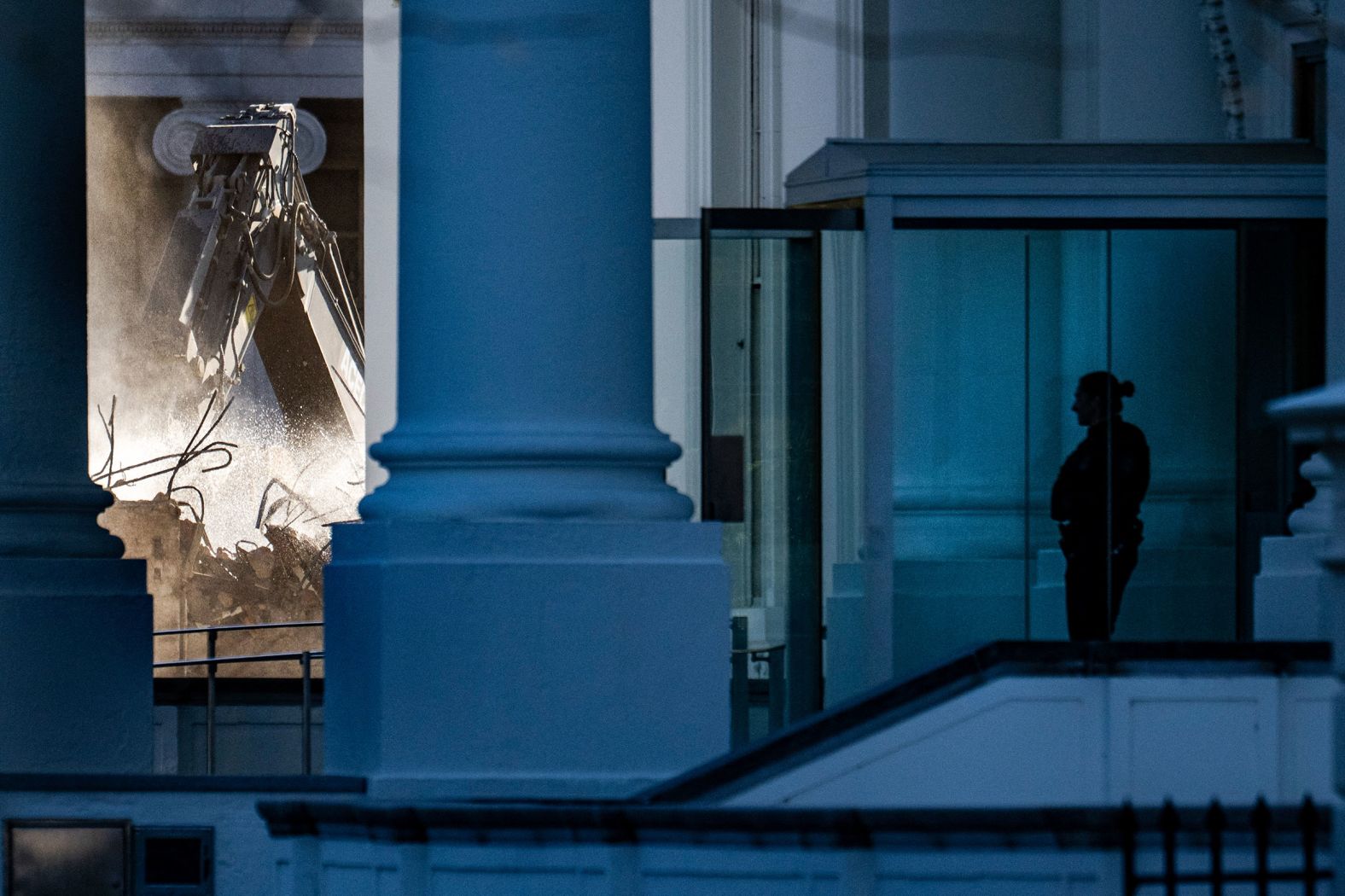 A uniformed member of the Secret Service stands guard as demolition continues on October 23.
