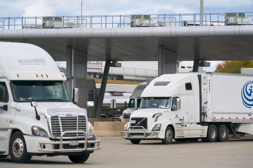 Commercial trucks cross into Canada from the US at the Blue Water Bridge border crossing in Sarnia, Ontario, on October 24, 2025.