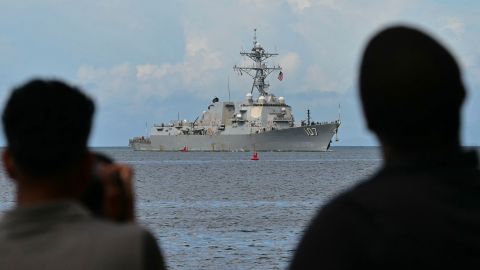 Photographers take pictures as the USS Gravely warship enters the port of Port of Spain on October 26, 2025. The US warship will visit Trinidad and Tobago for joint exercises near the coast of Venezuela amid Washington's campaign against alleged drug traffickers in the region.