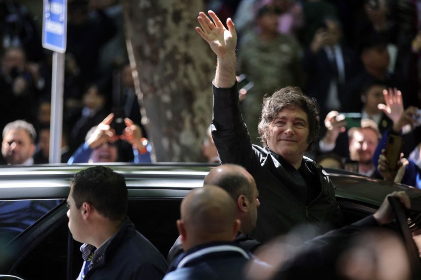 Argentina's President Javier Milei waves at supporters as he arrived to vote in Buenos Aires on October 26, 2025.