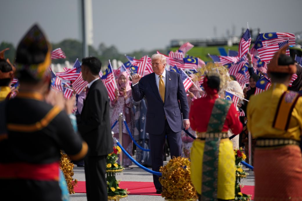 US President Donald Trump acknowledges the crowd as he boards Air Force One at the Kuala Lumpur International Airport on Monday in Kuala Lumpur, Malaysia.