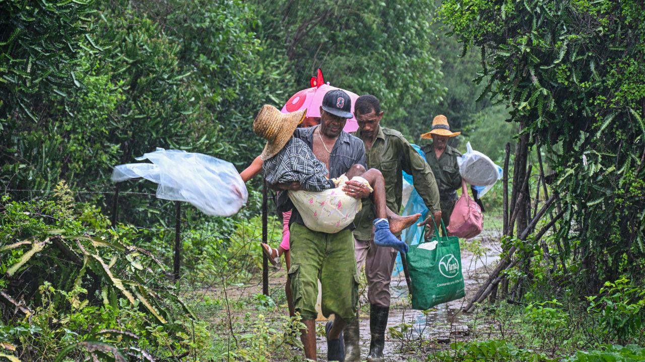 Residents self-evacuate under pouring rain from Playa Siboney to safe locations ahead of the arrival of Hurricane Melissa, in Santiago de Cuba, Cuba, on October 28, 2025.