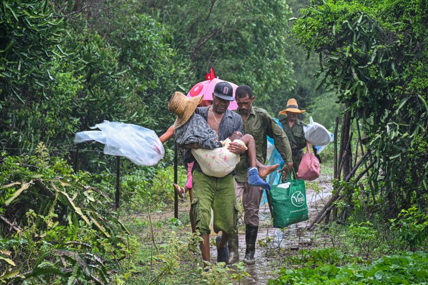 Residents self-evacuate under pouring rain from Playa Siboney to safe locations ahead of the arrival of Hurricane Melissa, in Santiago de Cuba, Cuba, on Tuesday.