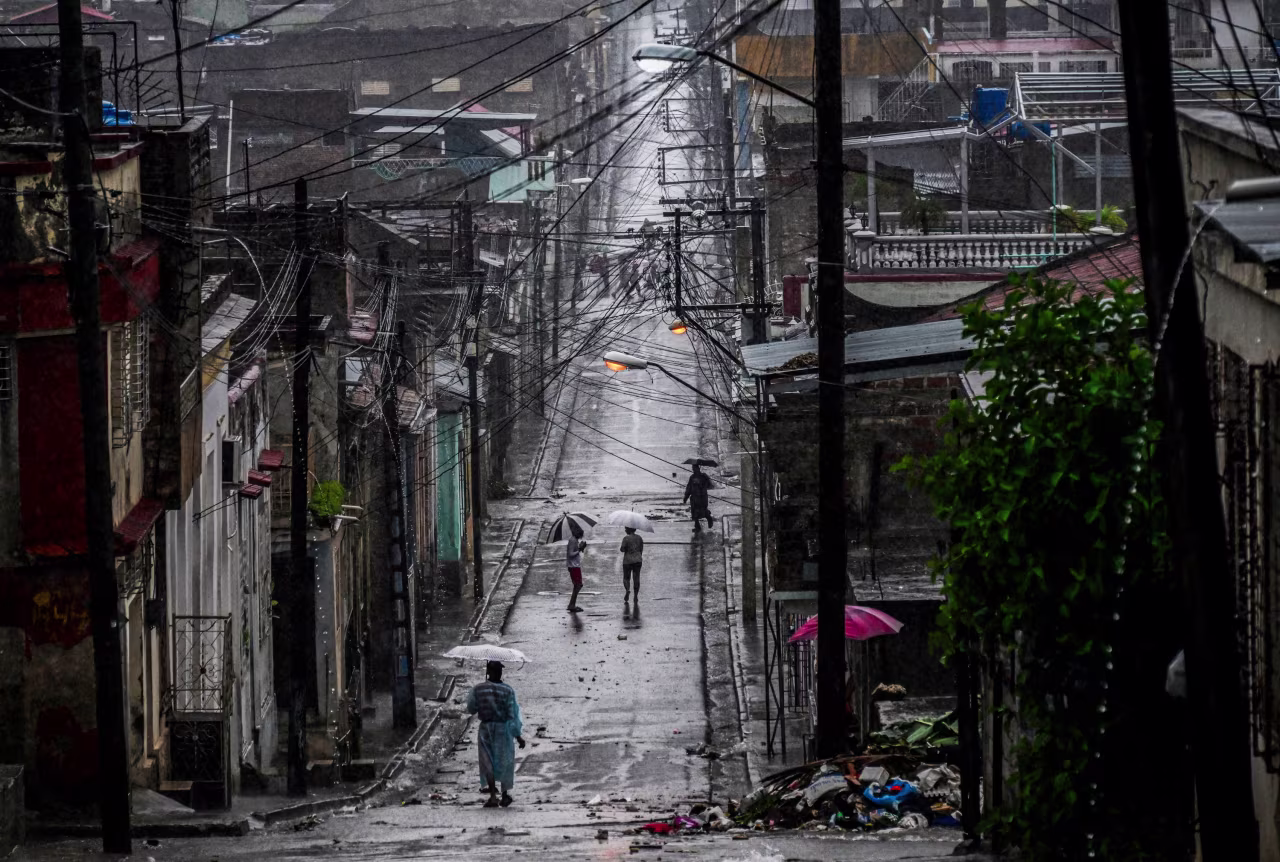 People walk in a street before Hurricane Melissa hits the city of Santiago de Cuba, Cuba on Tuesday.