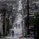 People walk in a street before Hurricane Melissa hits the city of Santiago de Cuba, Cuba on October 28, 2025. (Photo by YAMIL LAGE / AFP) (Photo by YAMIL LAGE/AFP via Getty Images)