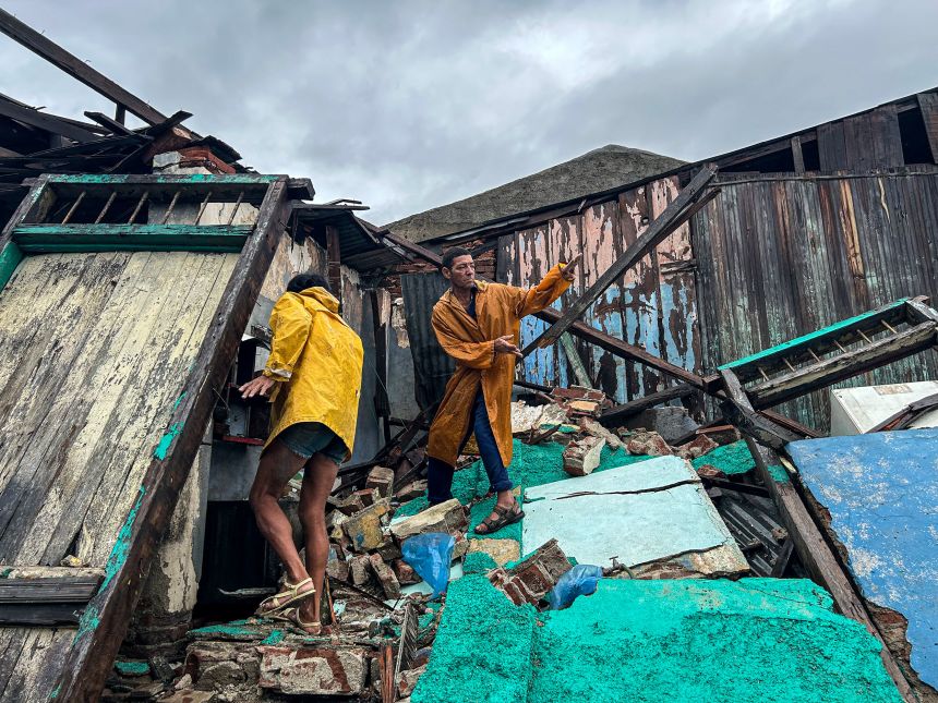 A family retrieves belongings from the rubble of their home in Santiago de Cuba, Cuba, on Wednesday.