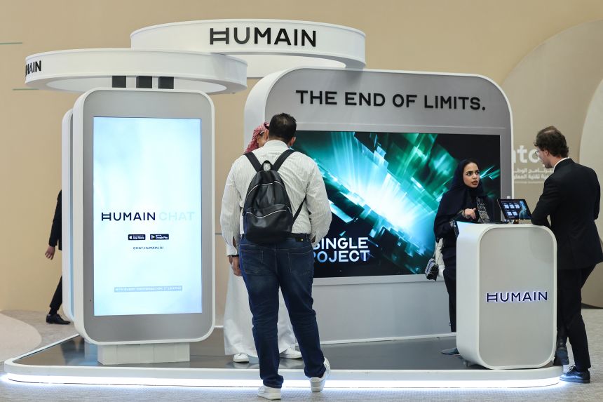 Guests stand at the booth of Saudi artificial intelligence company Humain.
