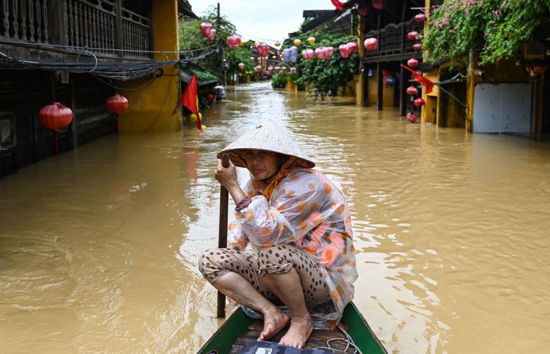 A woman rows a boat on a flooded street following heavy rains in Hoi An, Vietnam on October 30, 2025.