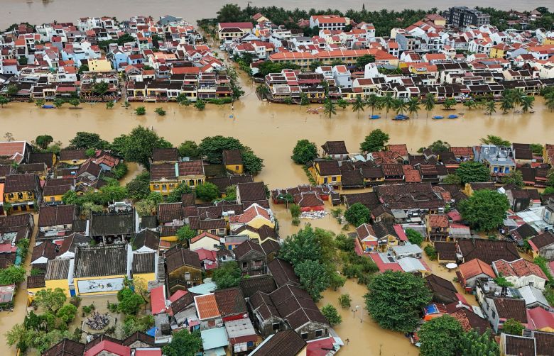 This aerial picture shows floodwaters inundating streets and buildings following heavy rains in Hoi An on October 30, 2025.