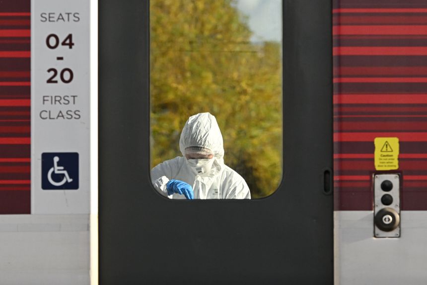 A forensic expert examines an LNER train at Huntingdon station on Sunday.