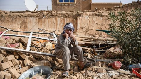 An Afghan earthquake survivor sits over the remains of a damaged house at a village in Tashqurghan, in the Khulm district of Samangan province, Afghanistan on November 3, 2025.