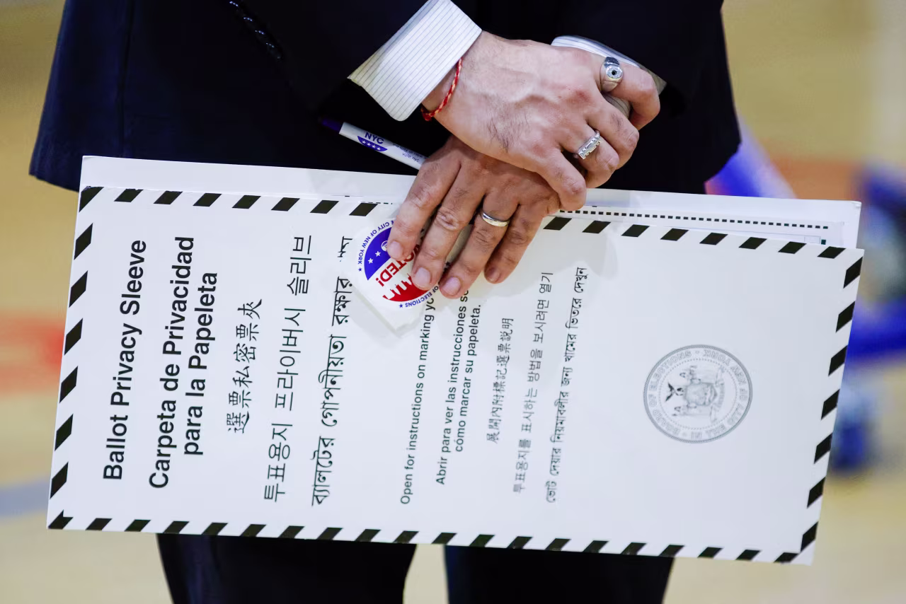 Zohran Mamdani holds his ballot and privacy sleeve after voting in the Queens borough of New York City on Tuesday.