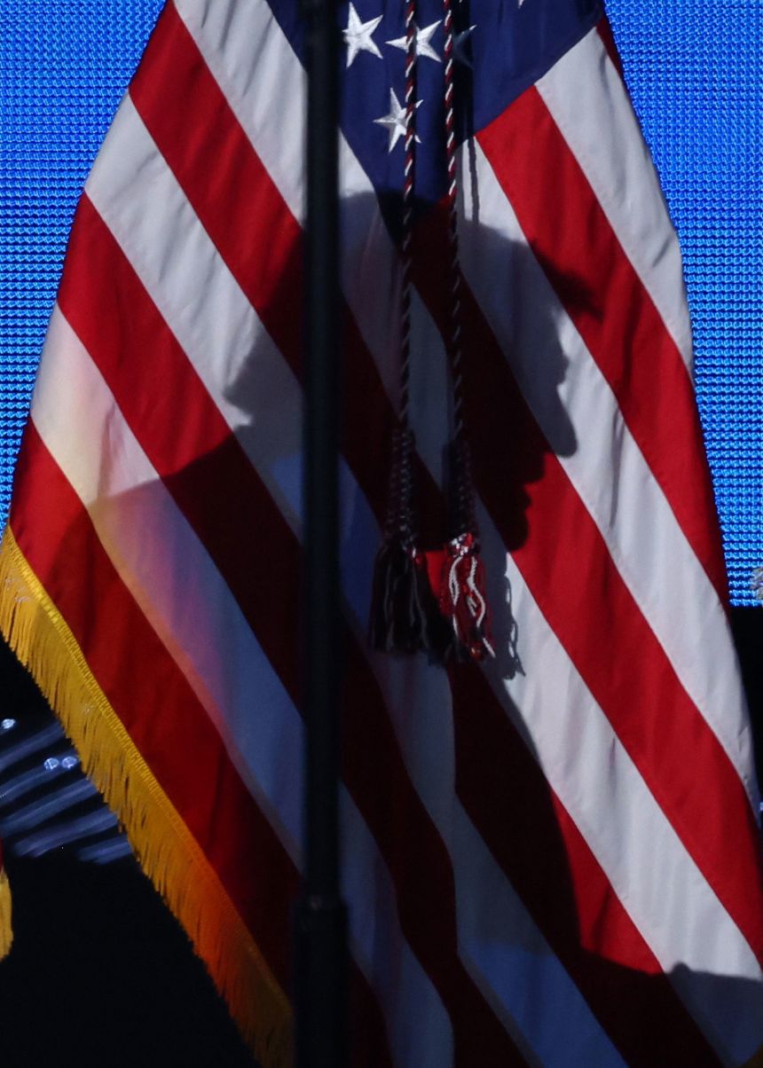 President Donald Trump's shadow is cast on an American flag as he walks on stage to speak in Miami, on November 5.