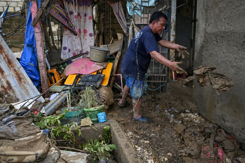 Мешканець прибирає свій будинок після того, як тайфун Калмегі обрушився на Лілоан, у провінції Себу 6 листопада.