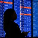 A traveler walks past the departures board at Ronald Reagan Washington National Airport in Arlington, Virginia on November 7, 2025.